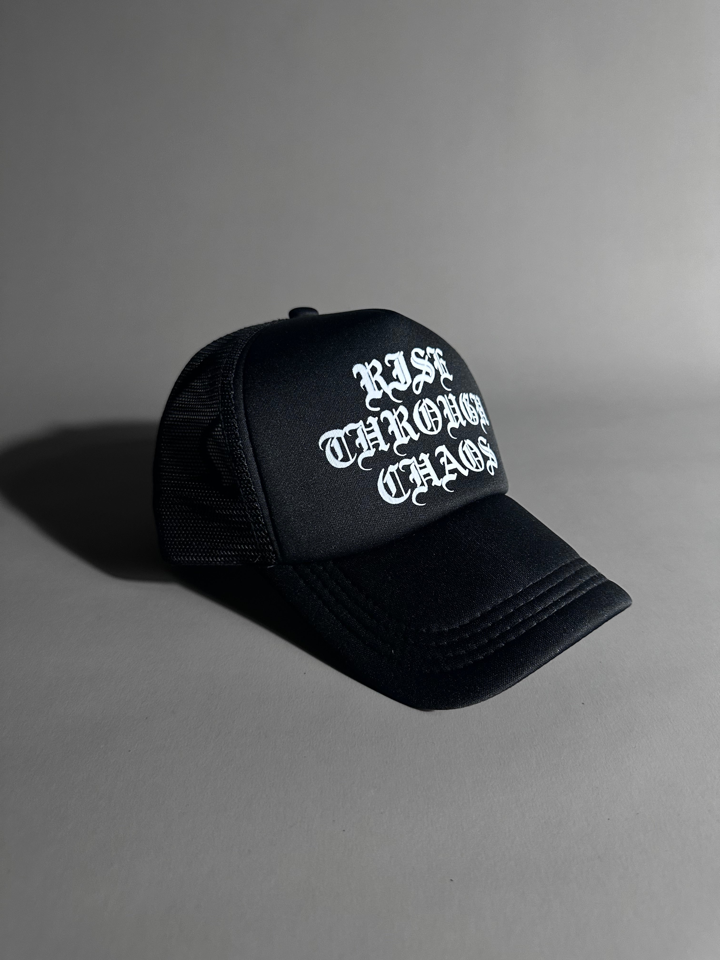 RISE THROUGH CHAOS TRUCKER HAT IN BLACK
