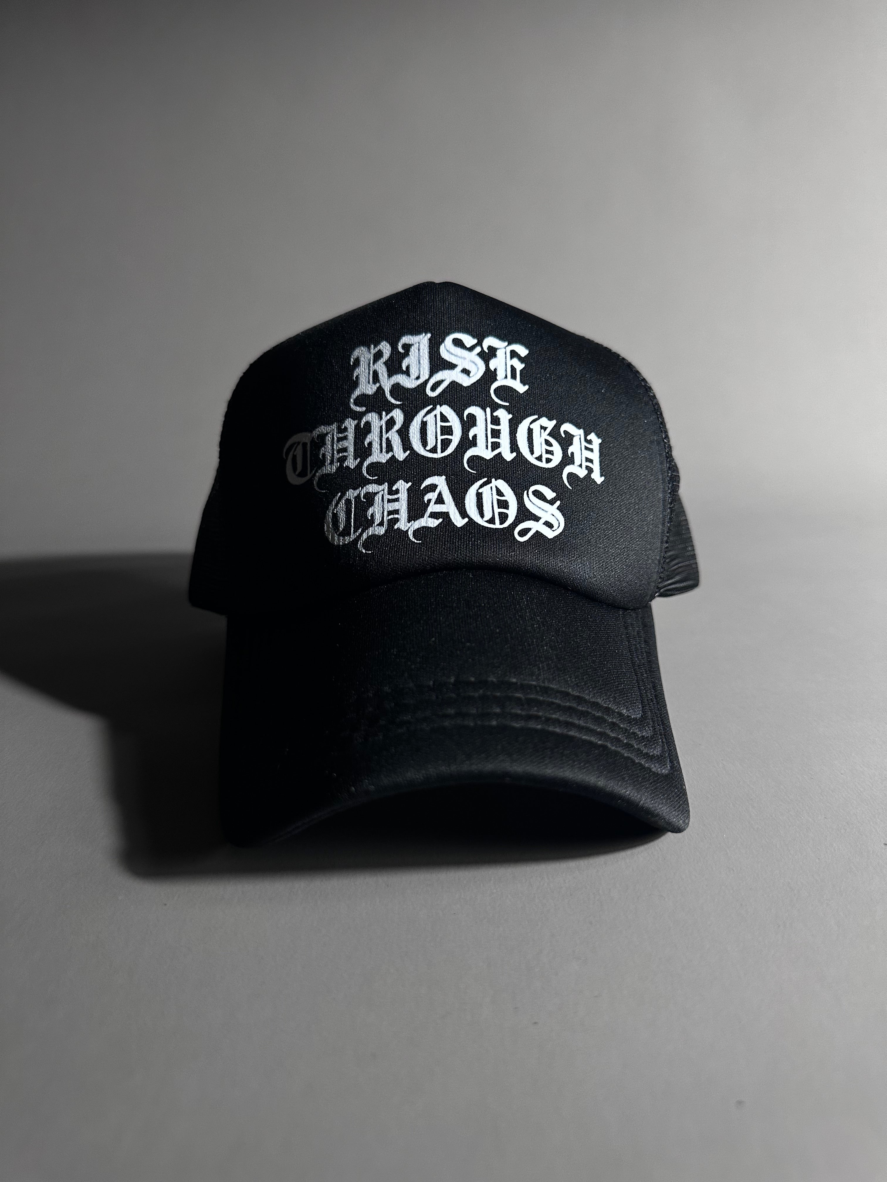 RISE THROUGH CHAOS TRUCKER HAT IN BLACK